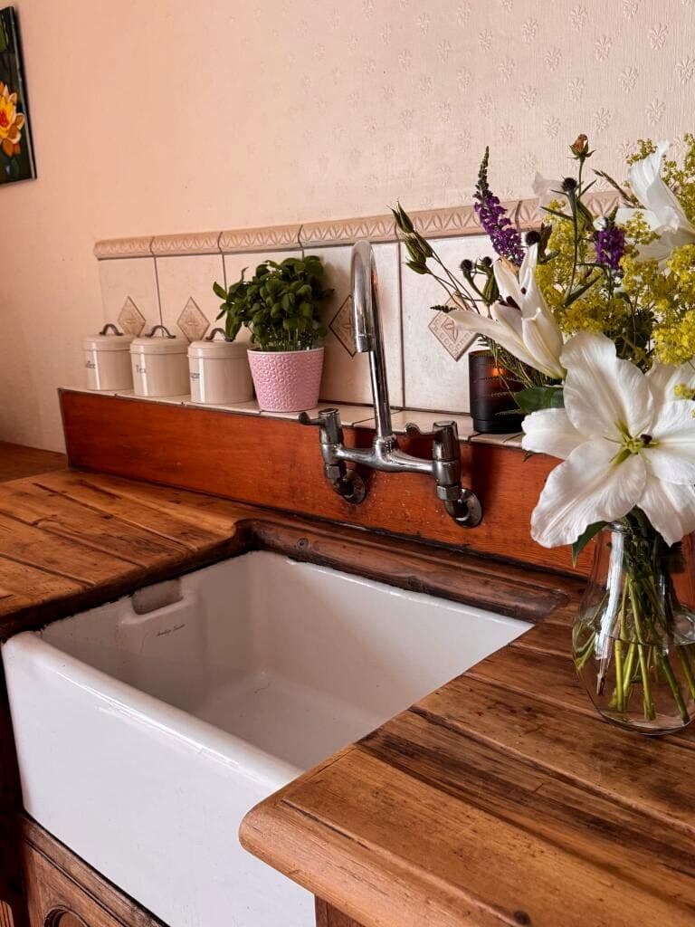 Belfast sink with flowers and timber worktop in the country kitchen
